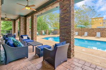 A patio with a pool and a ceiling fan.
